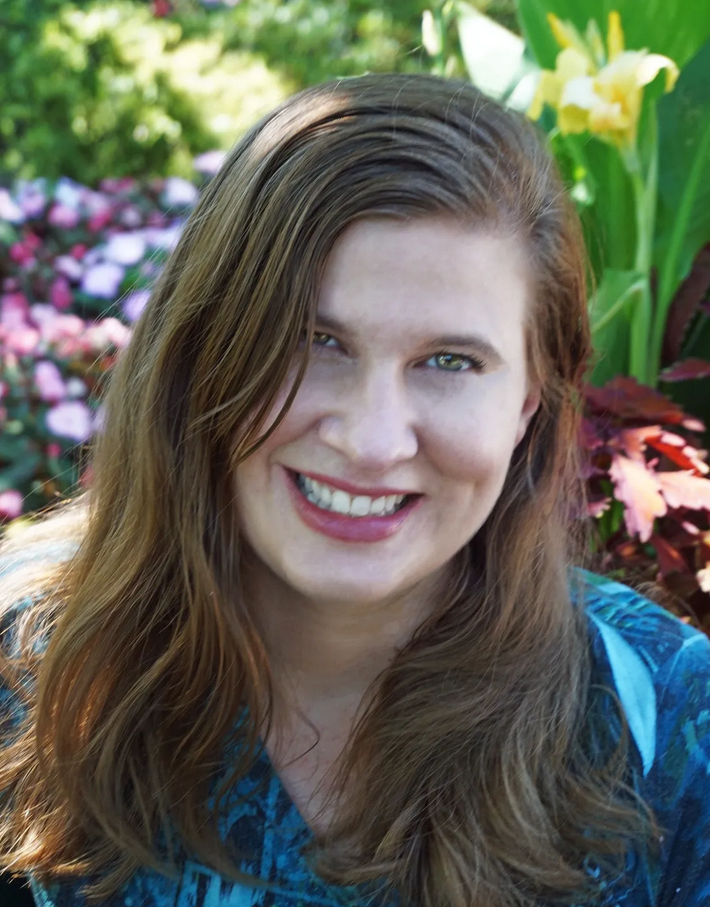 Kim Bullock, author, smiling in a garden