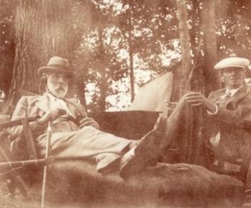 Carl Ahrens and Homer Watson seated outdoors in Alderside Park, New Dundee, Ontario, 1934, sepia photograph